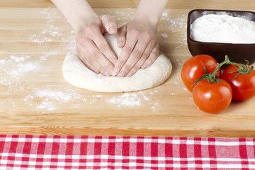 hand flattening the pizza dough