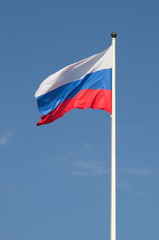 The state flag of the Russian Federation waving on blue sky background
