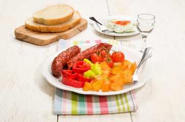 hungarian meal with fried potato, kolbasz, tomato and paprika