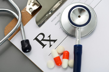 Prescription lying on clipboard pad with stethoscope