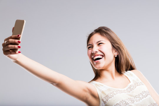 woman laughing at her mobile for a selfie