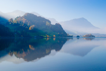 Canton Schwyz. Autumn. Reflections in calm water of the lake.