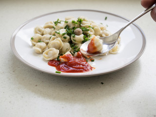 Picking meat dumplings with a spoon.