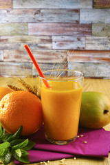Healthy fresh pressed mango and orange juice with grains and min
