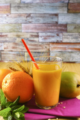 Healthy fresh pressed mango and orange juice with grains and min