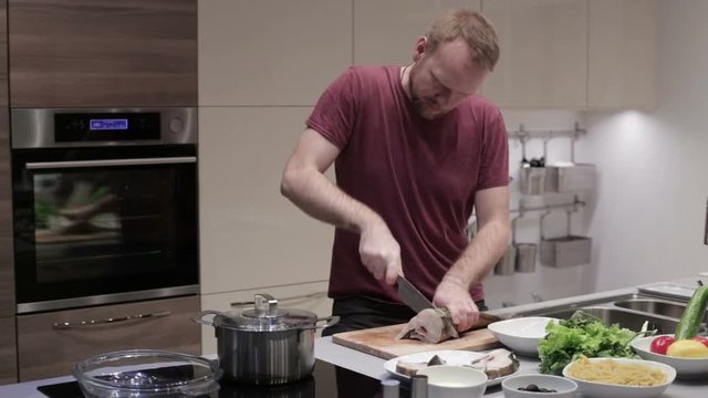 Man cut the fish into steaks