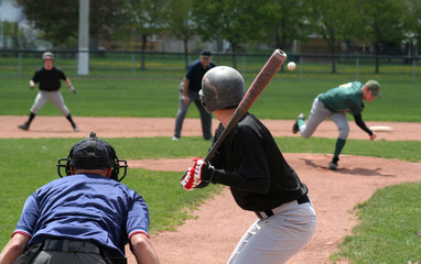 The pitcher has just released the ball, the batter is about to swing. - obrazy, fototapety, plakaty