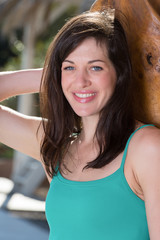 Portrait of beautiful young woman posing on sunny day against wo