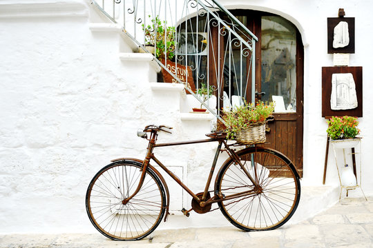 Fototapeta vintage bicycle against a wall in white city Ostuni, Apulia, Italy. - artistic picture italian style concept
