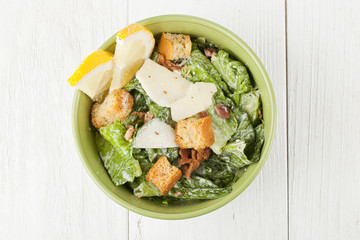 bowl of caesar salad with slice lemon