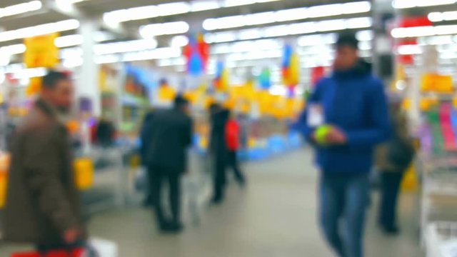 Supermarket interior with buyers, defocused blurred background