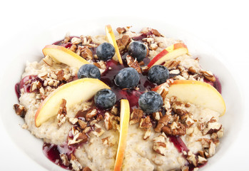 Oatmeal with apples, black berries, nuts and topping