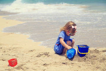 little girl play with sand on beach