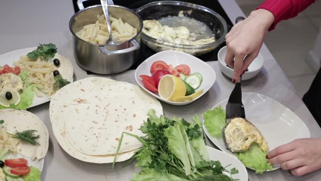Women's hands decorate a fish on a plate