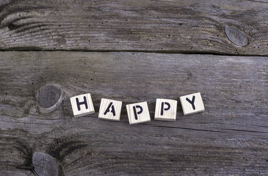 Text: Happy from wooden letters on wooden background