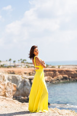 Fototapeta na wymiar Beautiful woman in yellow dress on the beach.