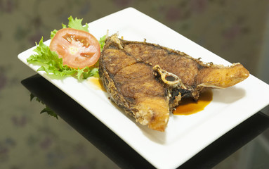 deep fried snapper fish with fish sauce on the plate.