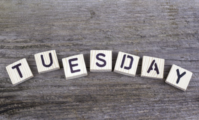 Fototapeta premium Text: Tuesday from wooden letters on wooden background