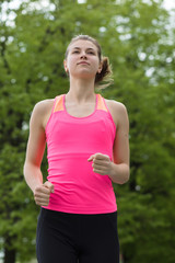 Fototapeta premium Young sporty woman running in park