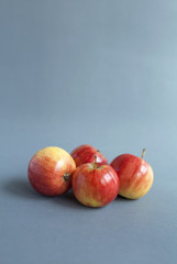 Fresh mini red apple on grey background, vertical style