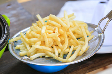 French fries cooking on deep fryer.