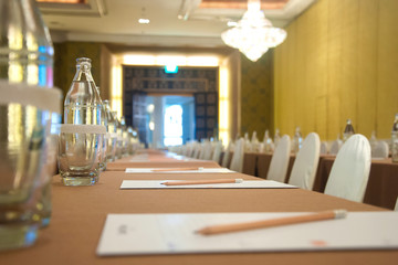 Paper, pencils and glasses on the table ready for conference