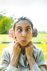 portrait of young beautiful woman with lollipops outdoors in spring day
