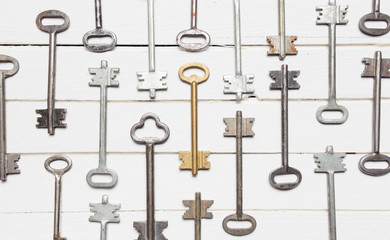 Some door keys aligned on old wooden surface, safety and security concept background