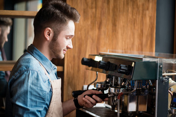 Pleasant barista making coffee 