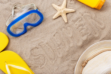 Inscription summer on beach sand with beach items,