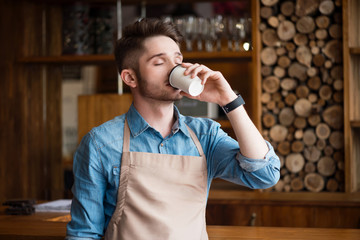 Pleasant waiter  drinking coffee  
