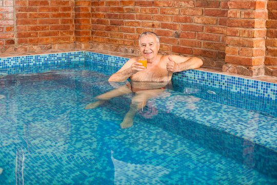 Happy Senior Man Is Relaxing In Hydromassage Pool.