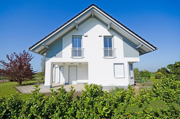 Weisses Einfamilienhaus im Sommer