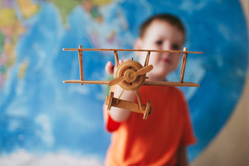 boy and a toy airplane standing at the map