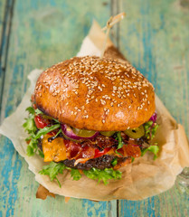 Tasty burgers on wooden table.