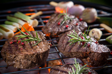 Delicious beef steaks with vegetable on a barbecue grill.
