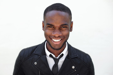 Happy young male fashion model in leather jacket and tie