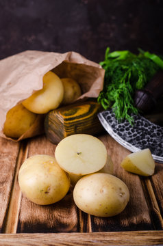 Fresh young potatoes on wooden background. Selective focus