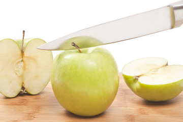 knife slicing apples on a plank