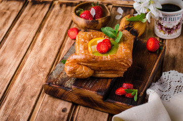 Freshly baked puff pastry with fruits and strawberries on wooden background. Selective focus. Top view