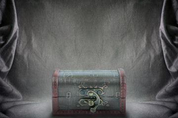 Treasure chest on backdrop crumpled fabric texture, cloth backgr