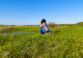 Naklejka na ściany i meble young woman photographer taking photo of the landscape