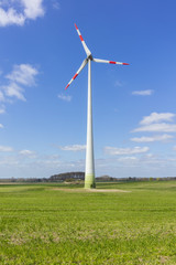 Fototapeta premium Sachsen-Anhalt neu gebautes Windrad auf grüner Wiese Ökologie Blauer Himmel Wolken Windenergie Gras freie Wiese Feld Landschaft Natur Naturschutz Genehmigunsverfahren aufstellung errichtung aufbau 
