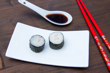 Maki with shrimps on a wooden table seen up close