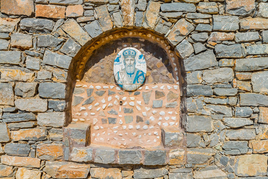 Beautiful stone wall of the orthodox church of Saint Nicholas the Wonderworker, built under the rock. District of Rethymno. Crete island. Greece. Europe.