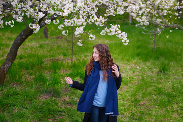 Portrait of young beautiful woman in spring blossom trees