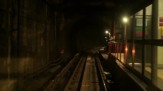 Camera Moves Forward along Metro Rails in Dark Tunnel