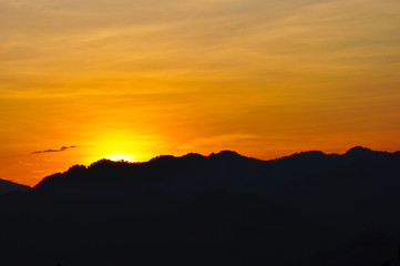 Sunset with silhouette mountain.
