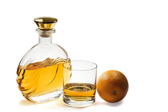 Bottle and glass whiskey with orange on white background
