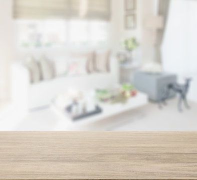 wooden table top with blur of living space interior